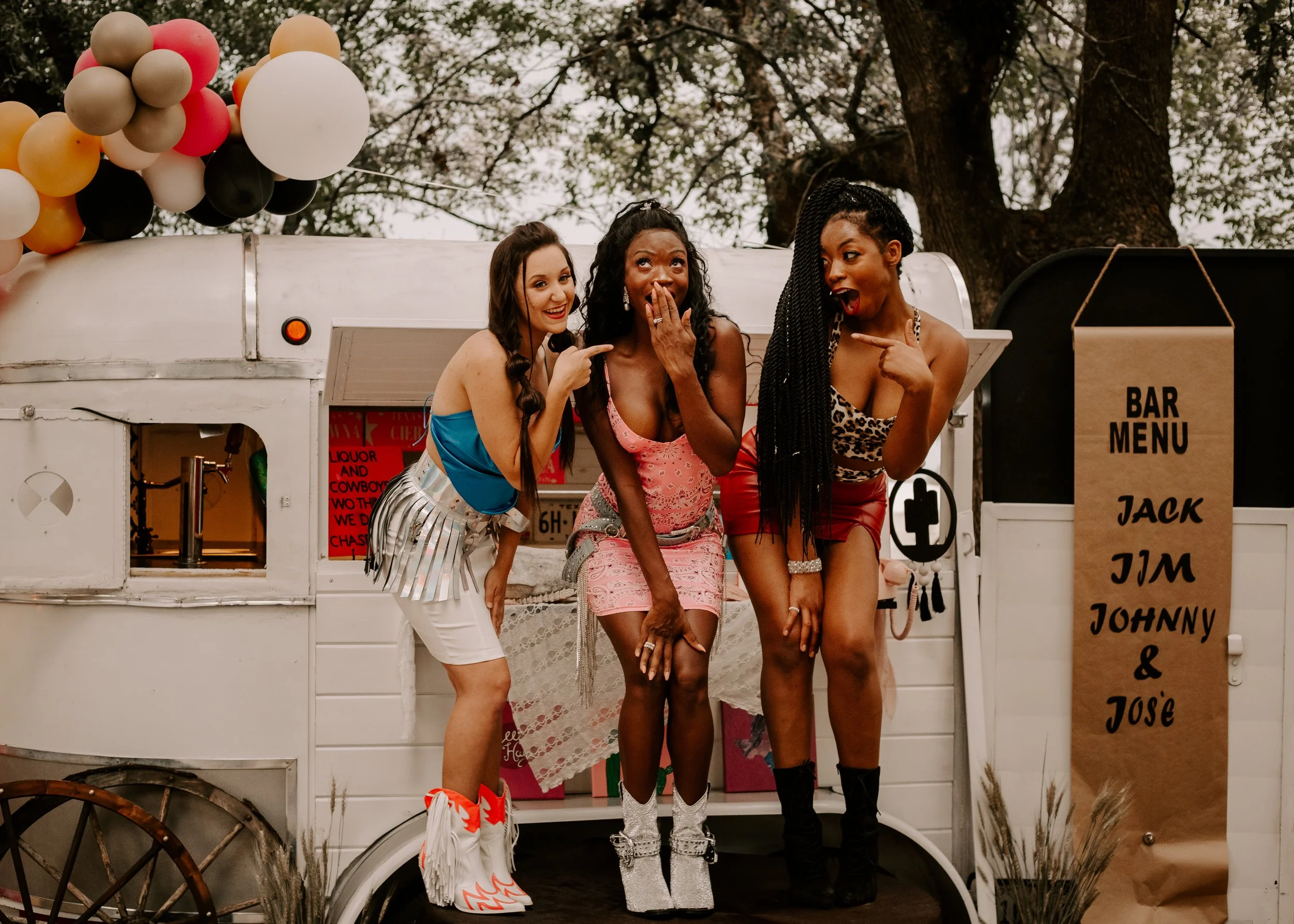Friends celebrating in front of mobile bar trailer