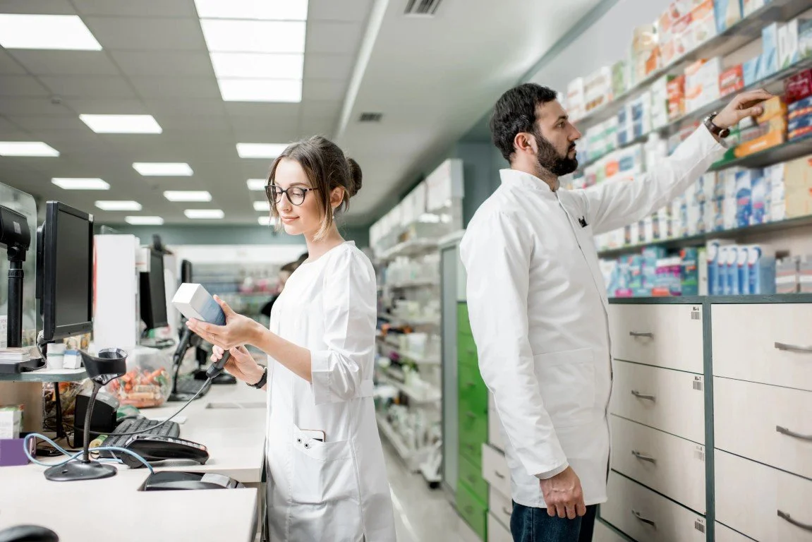 Pharmacists in Open Health Care Clinic's in-house pharmacy organizing medicine inventory