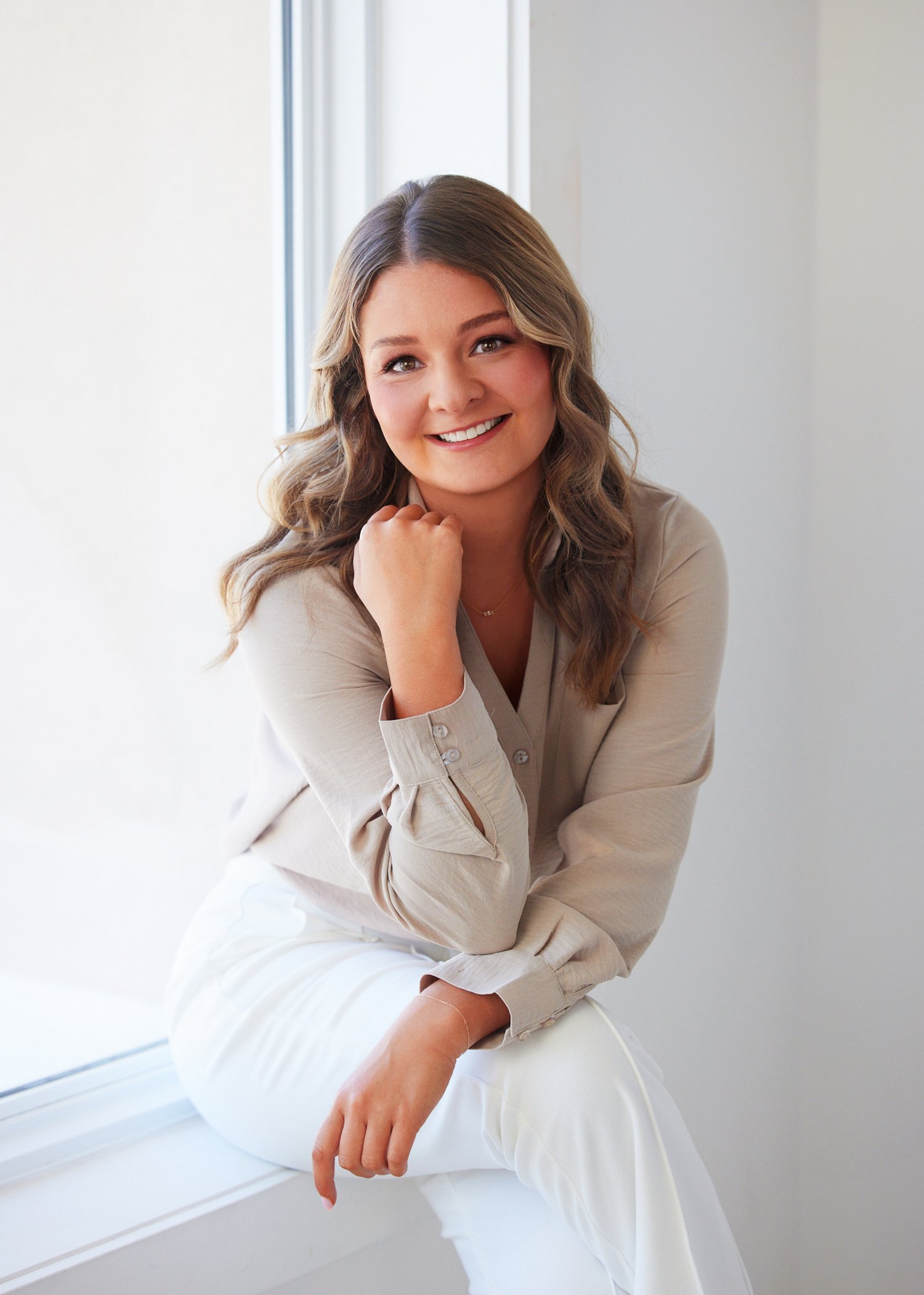 Kansas City professional Hunter Hamblin leaning against a wall with a confident, approachable smile during her branding session