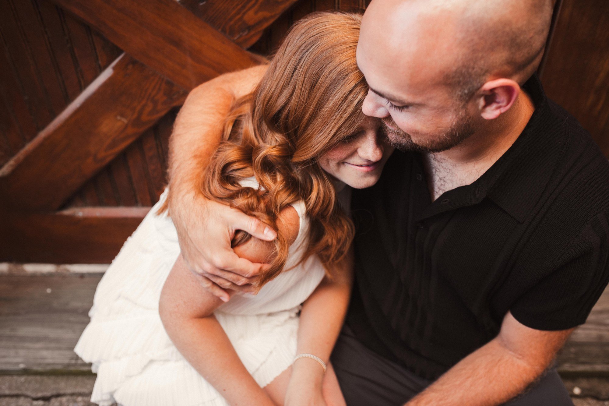 Jacob holding Erin close beside a wooden doorway, viewed from above.