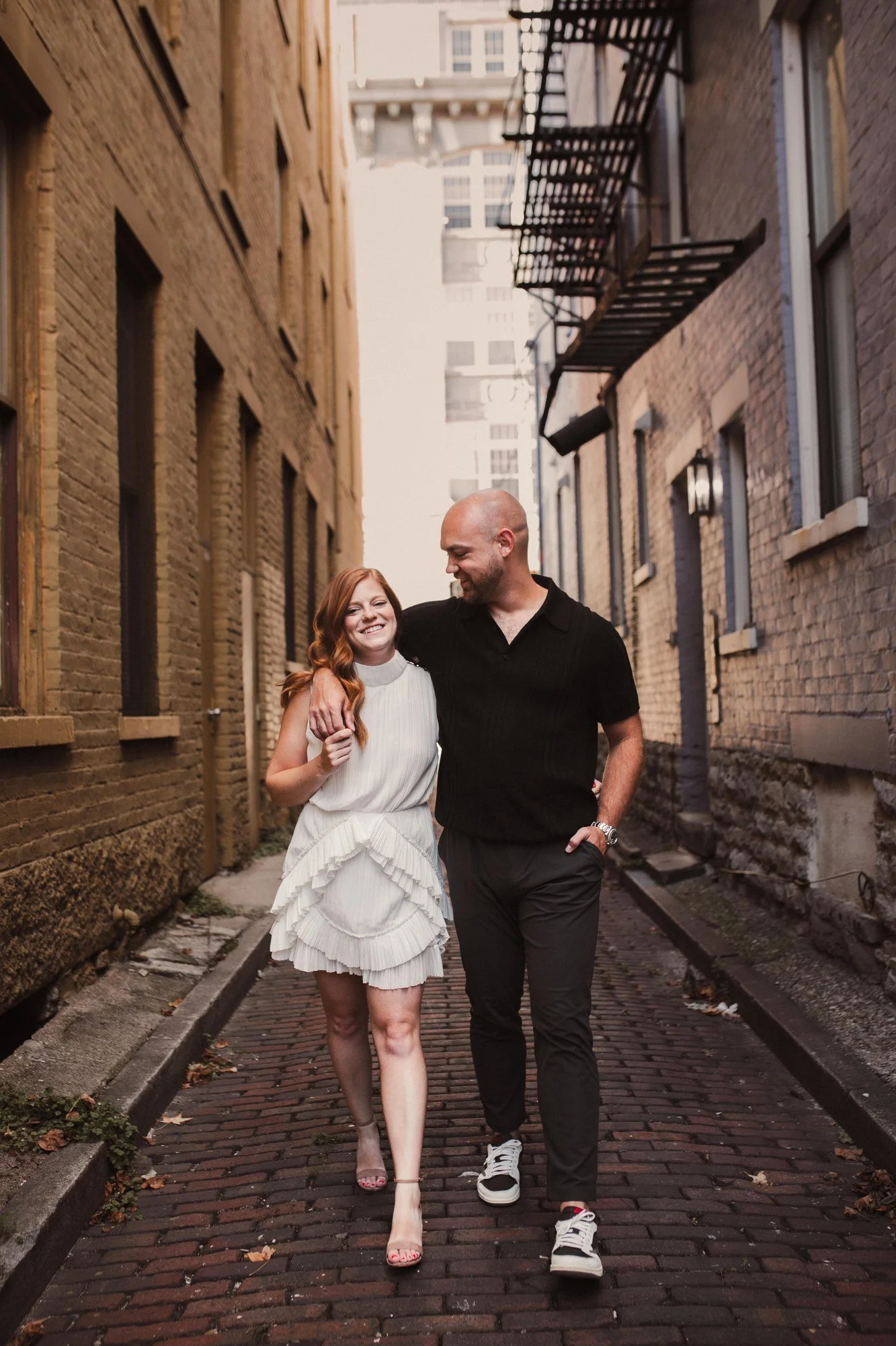 Jacob and Erin walking hand in hand through an Over-the-Rhine alley.