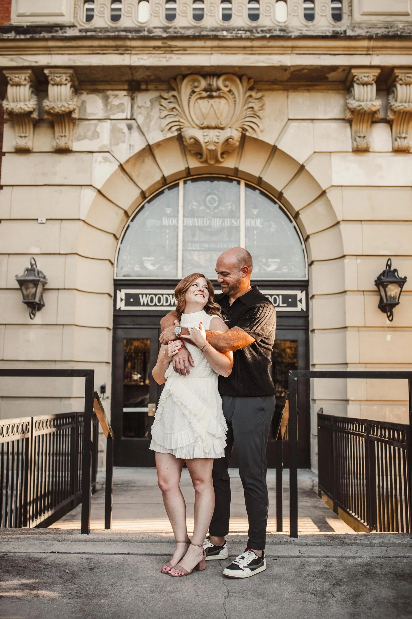 Jacob and Erin embracing in front of an ornate stone building.