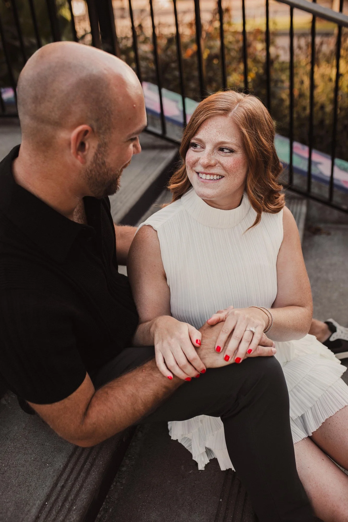 Erin smiling at Jacob while they sit close together on stone steps.