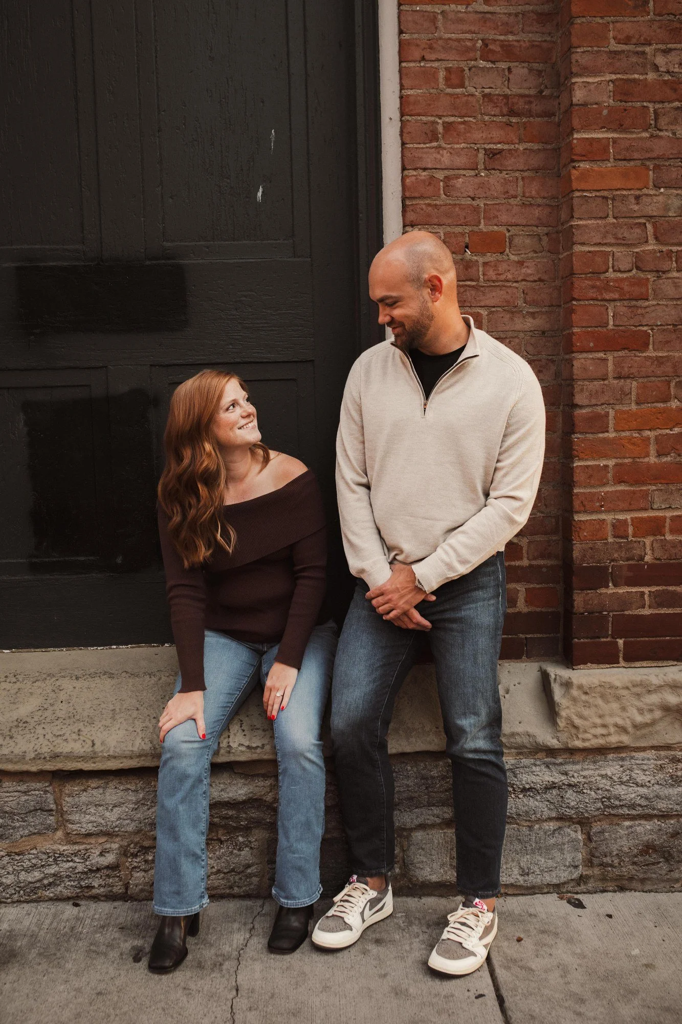 Jacob and Erin looking at each other beside a dark doorway.