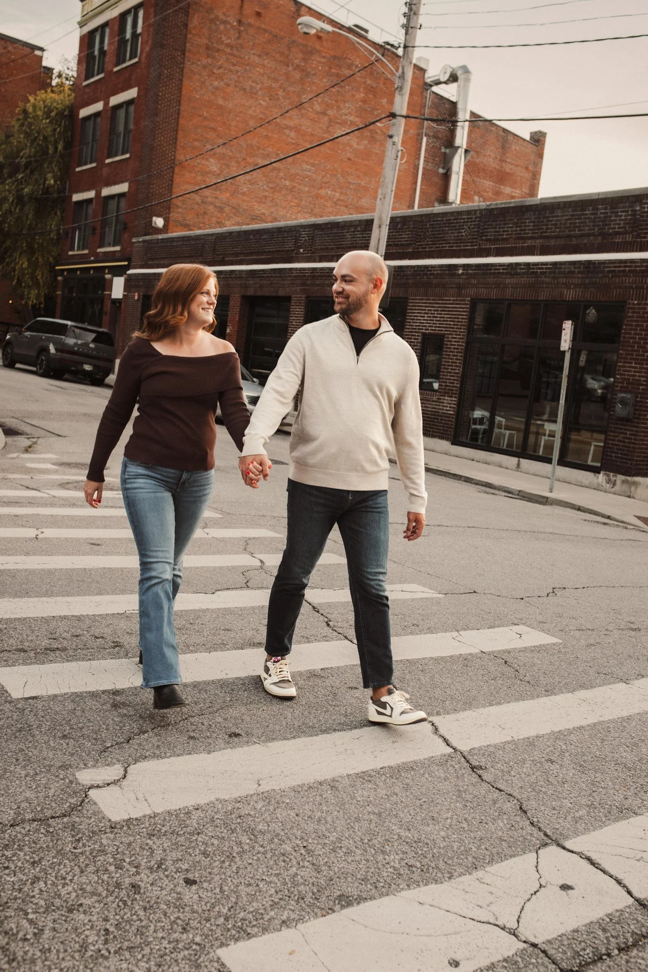 Jacob and Erin walking hand in hand across a Cincinnati street.