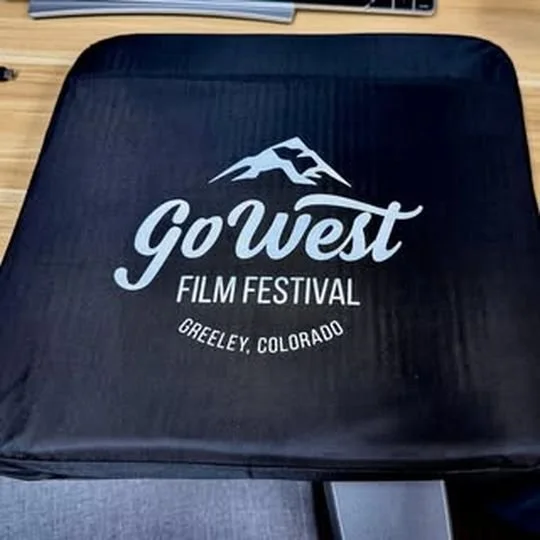 Black Go West Film Festival seat cushion with the white festival logo