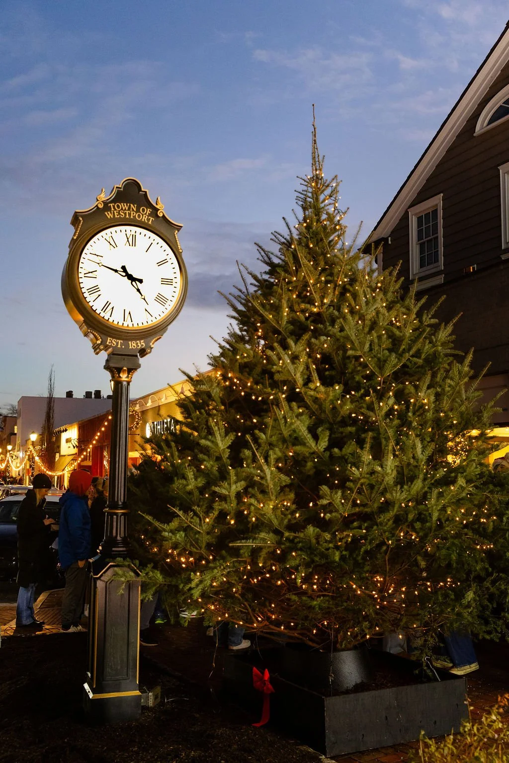 The downtown clock and holiday tree at dusk
