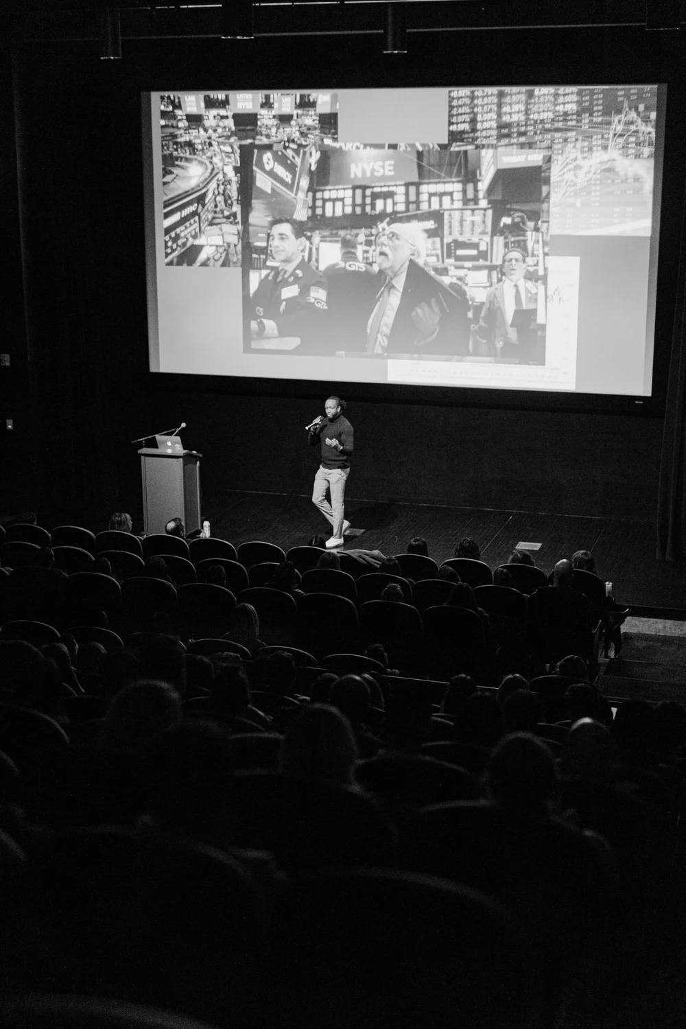 Leadership keynote speaker Attah Obande on stage presenting to a large theater audience
