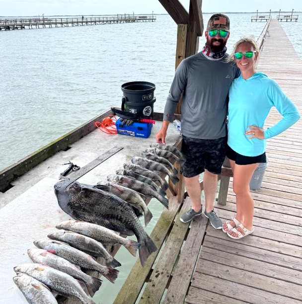 Two anglers beside their multi-species catch after a Rockport full-day fishing trip