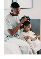 Photograph of Dad helping little girl with her hair
