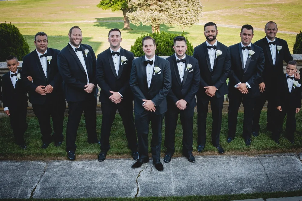 Aldrich Mansion wedding photographer, Warwick, RI — groom and groomsmen in black tuxedos along the stone balustrade
