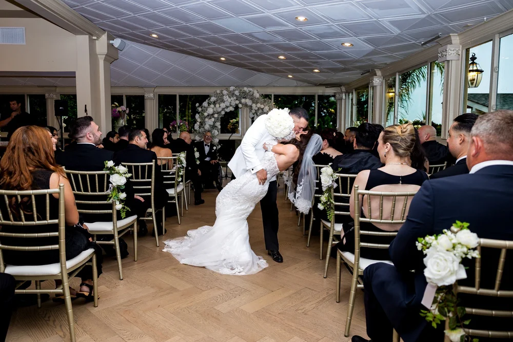 Anthony's Ocean View wedding videographer, New Haven, CT — groom dipping the bride for a kiss down the ceremony aisle