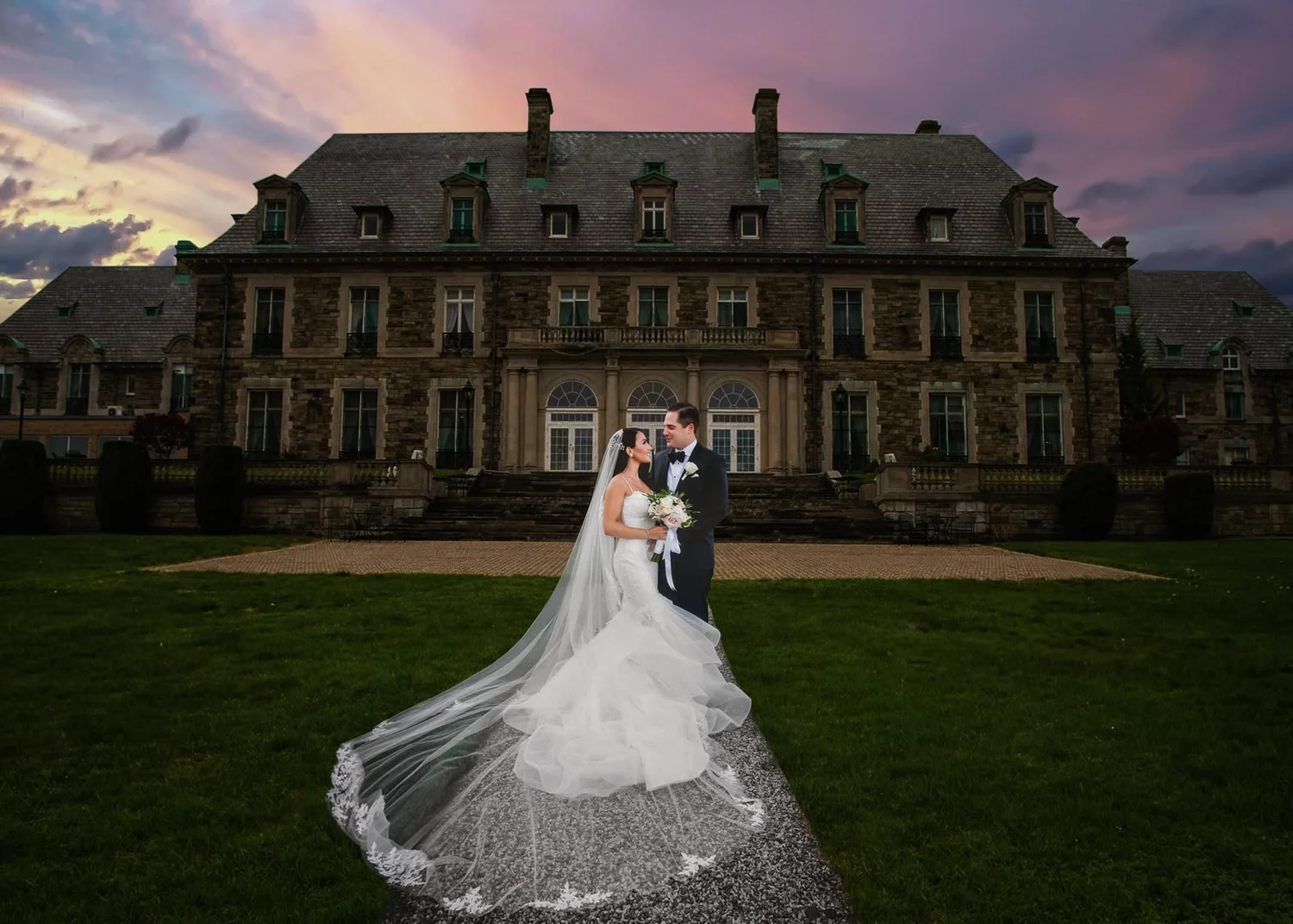 Aldrich Mansion wedding photographer, Warwick, RI — bride and groom on the lawn in front of the 70-room French chateau at sunset