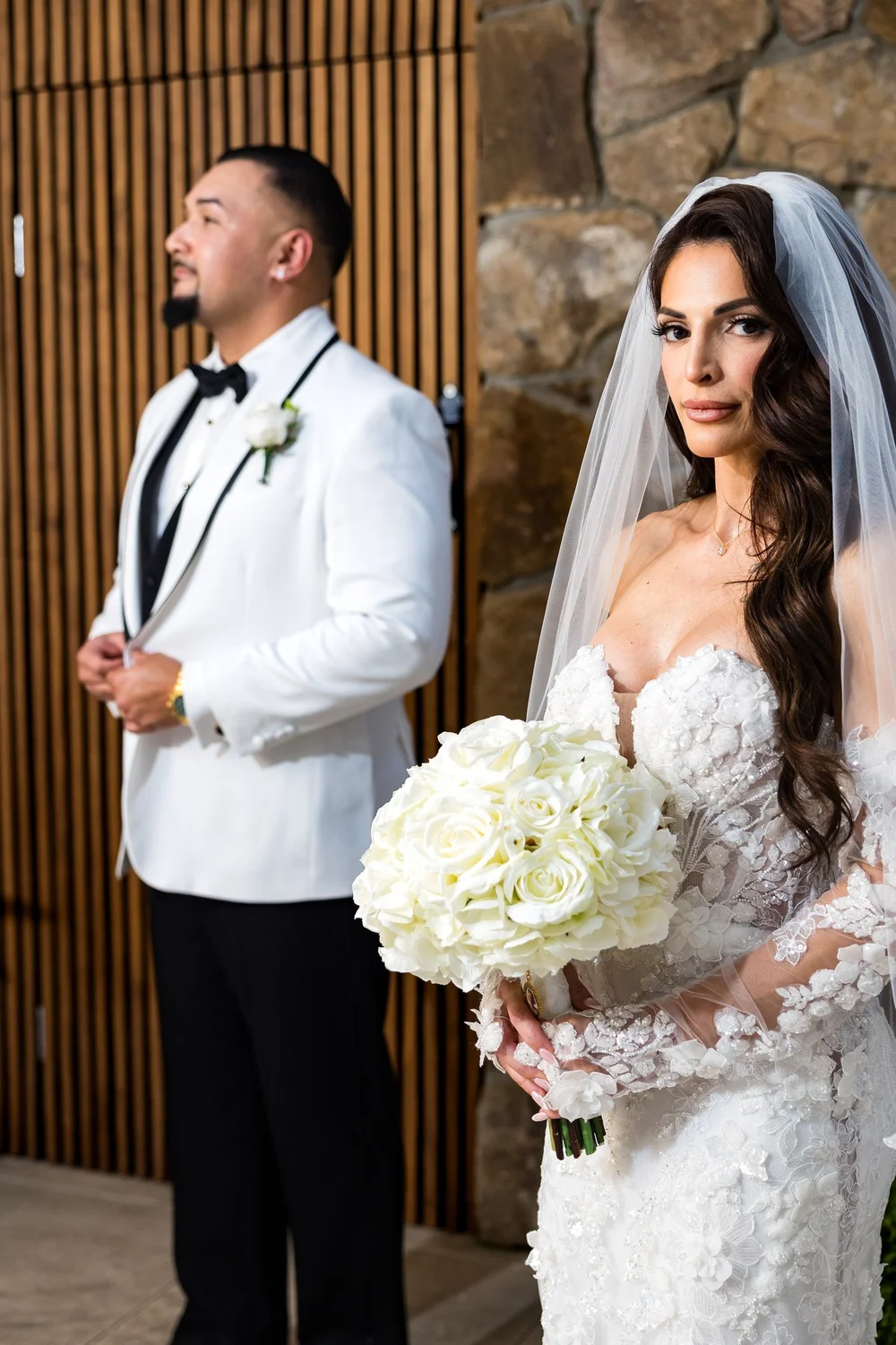 Anthony's Ocean View wedding photographer, New Haven, CT — bride holding a white rose bouquet beside the stone accent wall