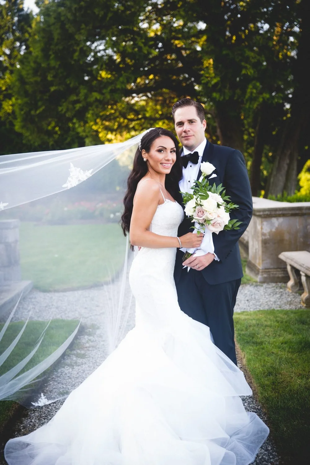 Aldrich Mansion wedding photographer, Warwick, RI — sunlit portrait of the bride and groom with her veil floating in the garden