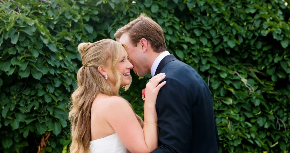 The Gardens at Elm Bank wedding videographer, Wellesley, MA — bride and groom laughing together in the lush garden