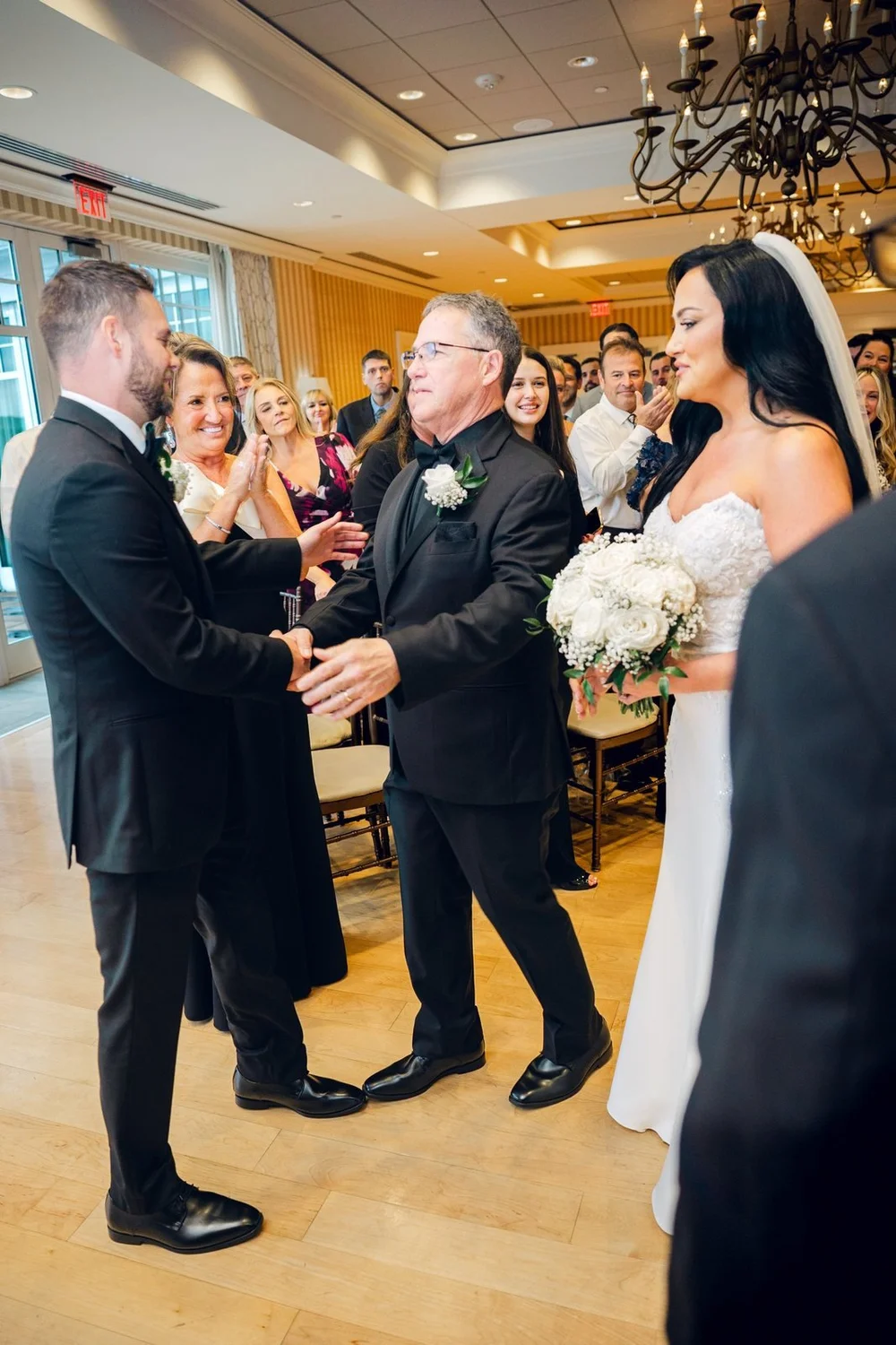 Beauport Hotel wedding videographer, Gloucester, MA — couple joining hands with the officiant during the Grand Ballroom ceremony