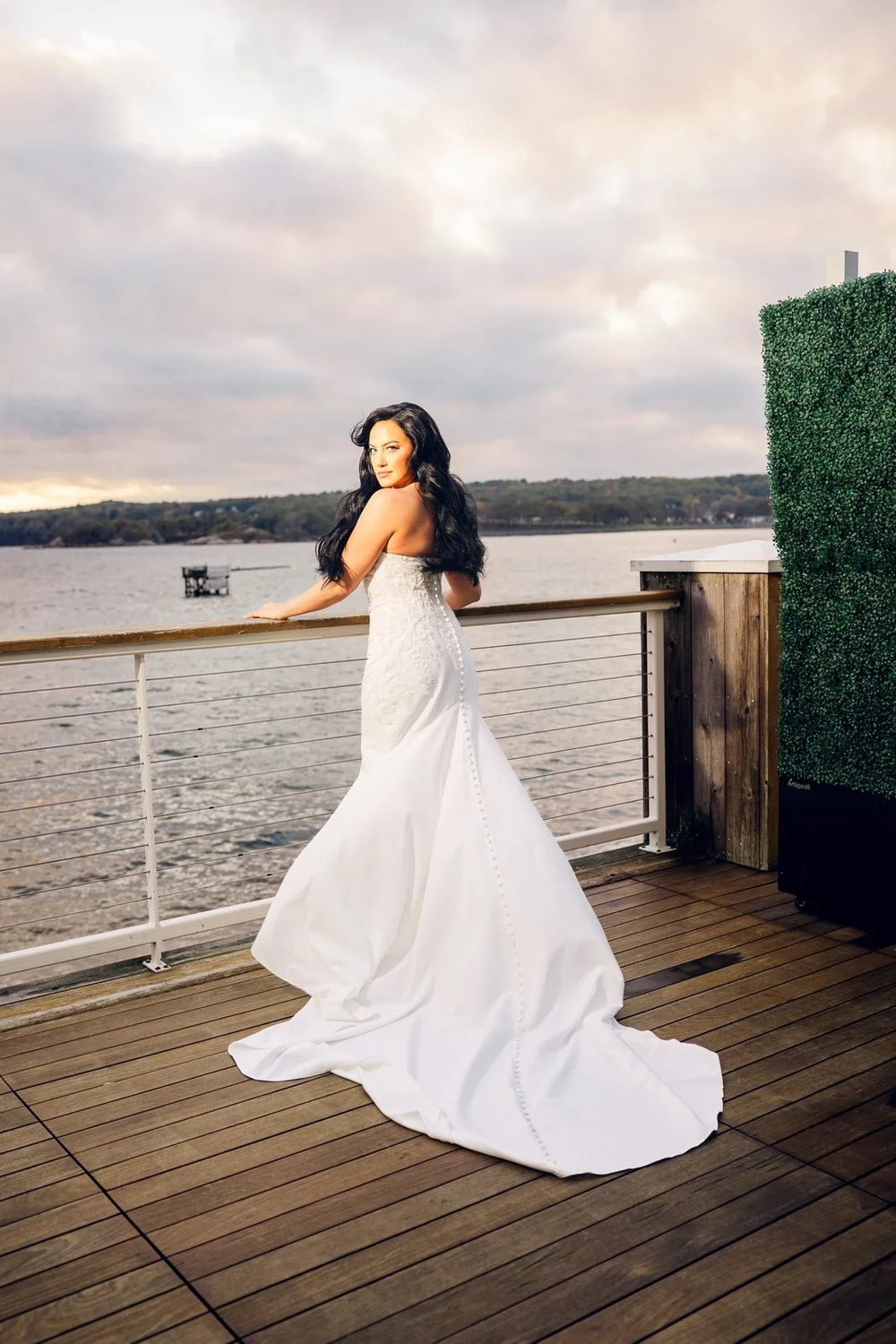 Beauport Hotel wedding photographer, Gloucester, MA — bride on the harborfront deck with Gloucester Harbor stretching out behind her