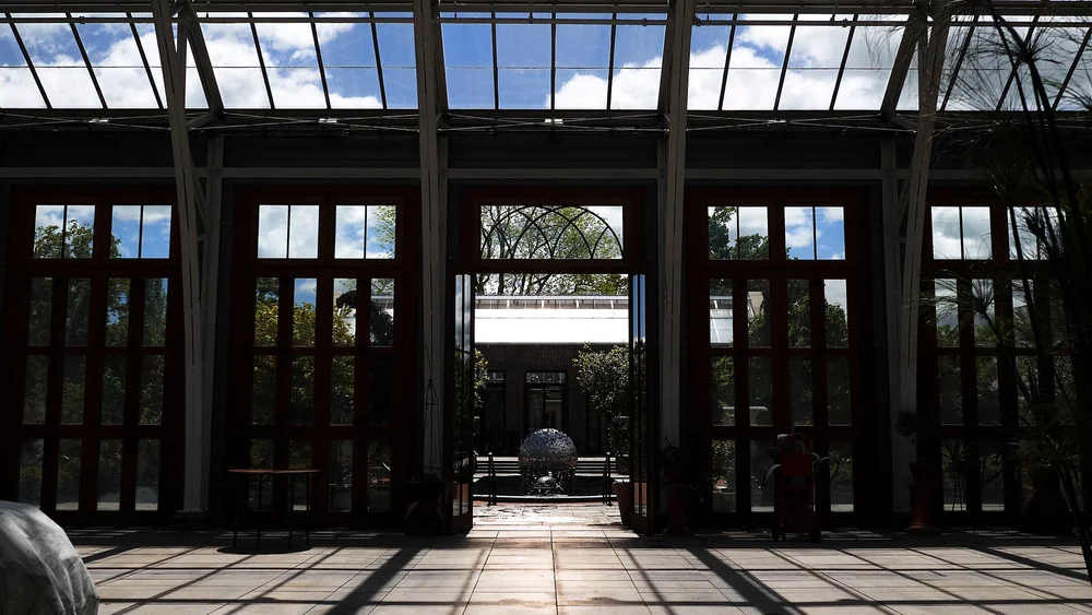 Arched French doors inside the Orangerie conservatory looking toward the terrace at New England Botanic Garden at Tower Hill, Boylston, MA