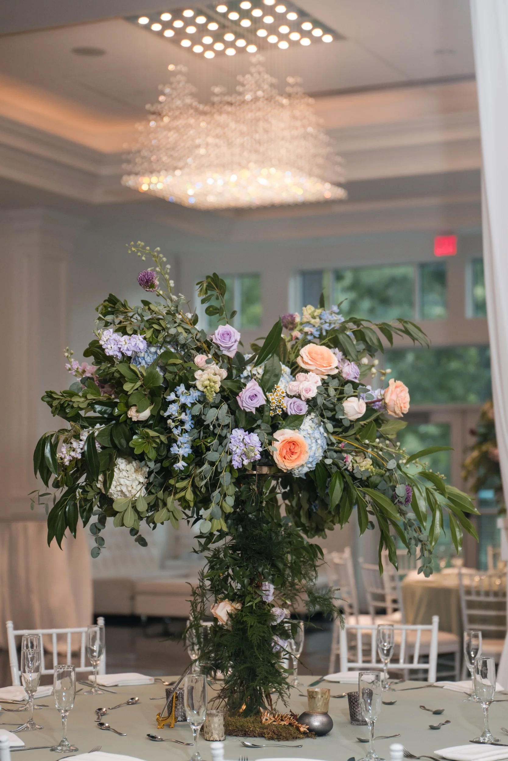 Tall floral centerpiece beneath a crystal chandelier at a Lakeview Pavilion reception, Foxborough, Massachusetts