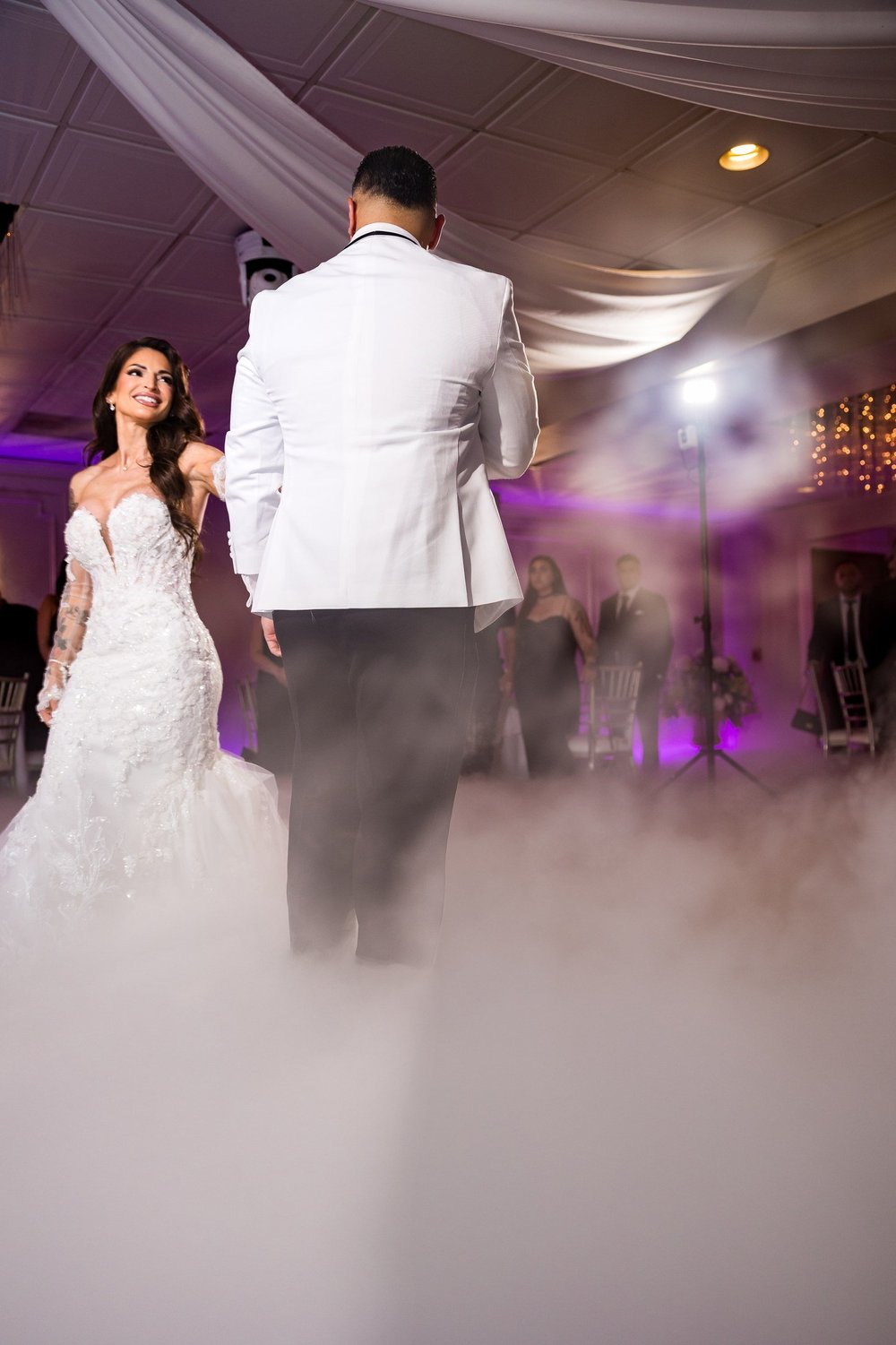 Anthony's Ocean View wedding videographer, New Haven, CT — bride smiling during the first dance on the clouds in the grand ballroom