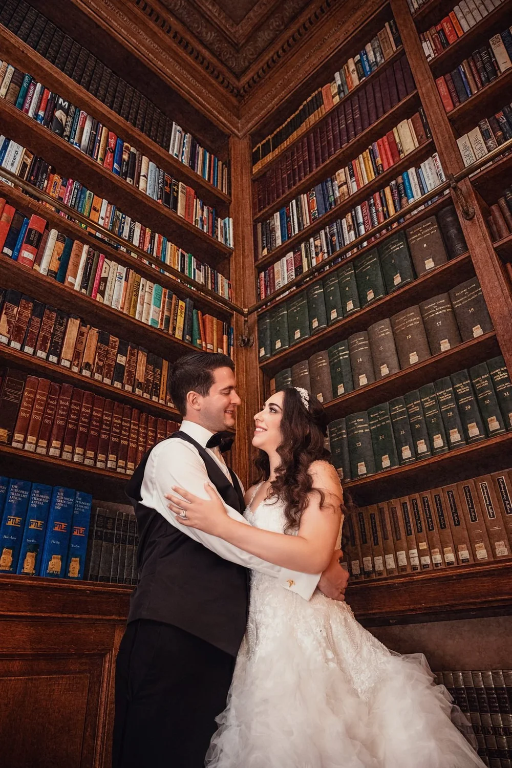Aldrich Mansion wedding photographer, Warwick, RI — bride and groom embracing inside the floor-to-ceiling wood-paneled library