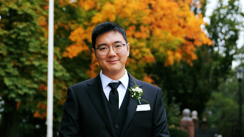 The Gardens at Elm Bank wedding photographer, Wellesley, MA — groom portrait in front of vibrant orange fall foliage