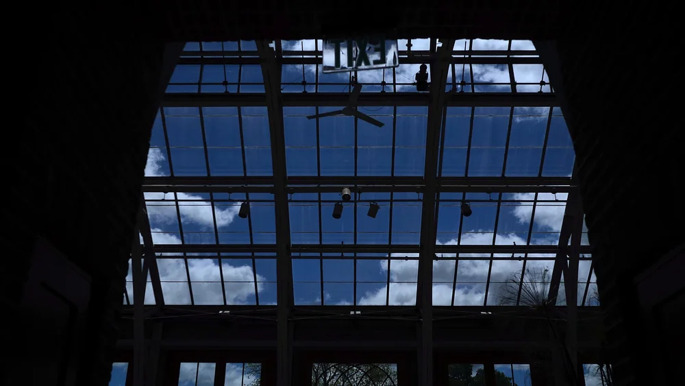 Orangerie glass conservatory roofline and arched windows against blue sky at New England Botanic Garden at Tower Hill, Boylston, MA