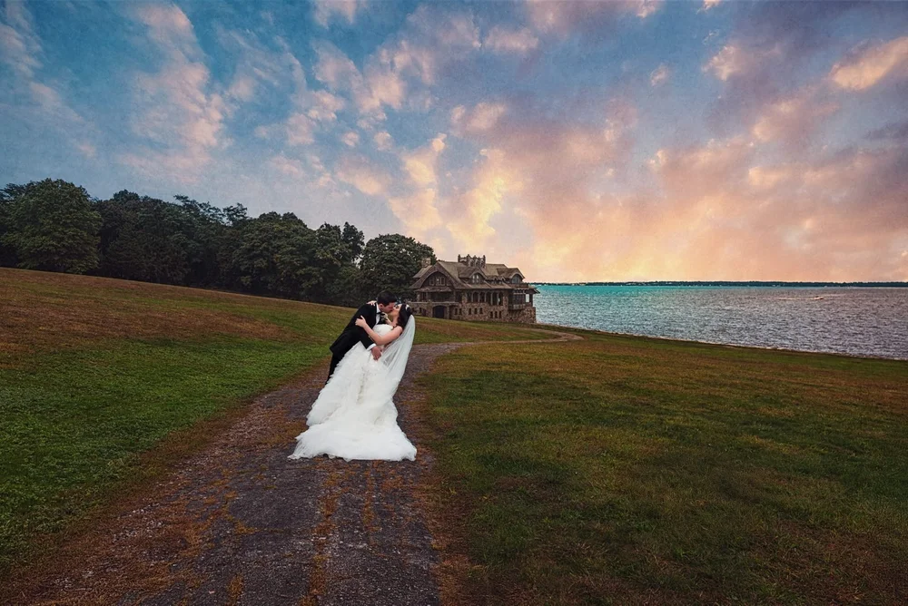 Aldrich Mansion wedding videographer, Warwick, RI — groom dipping the bride for a sunset kiss overlooking Narragansett Bay and the stone boathouse