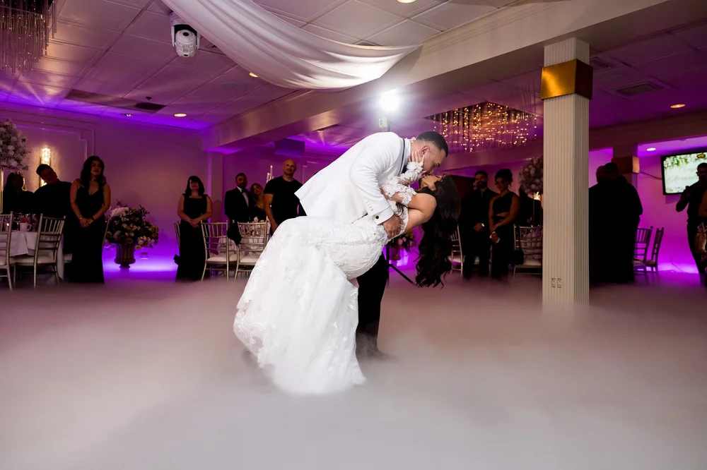 Anthony's Ocean View wedding videographer, New Haven, CT — groom dipping the bride for a kiss on a cloud-covered ballroom dance floor