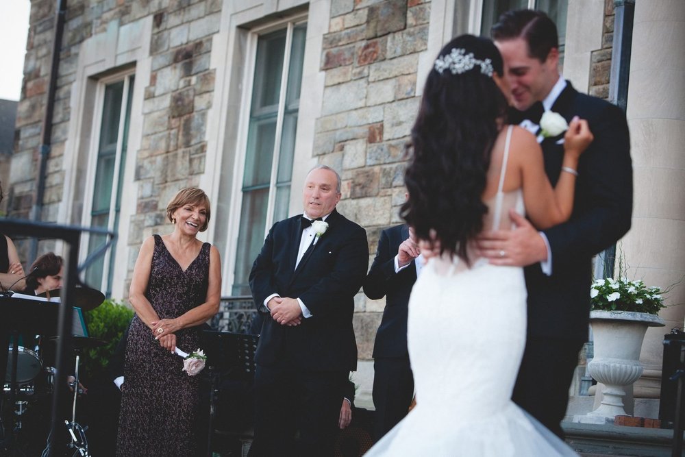 Aldrich Mansion wedding videographer, Warwick, RI — bride's parents watching the couple's first dance on the stone terrace