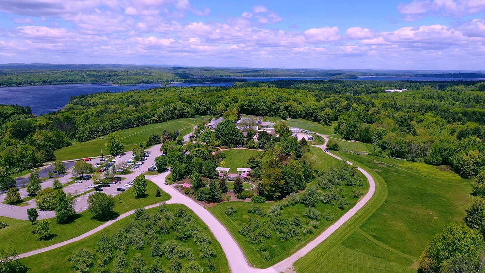 Daytime aerial view of the Orangerie conservatory and hilltop garden grounds at Tower Hill Botanic Garden in Boylston, Massachusetts
