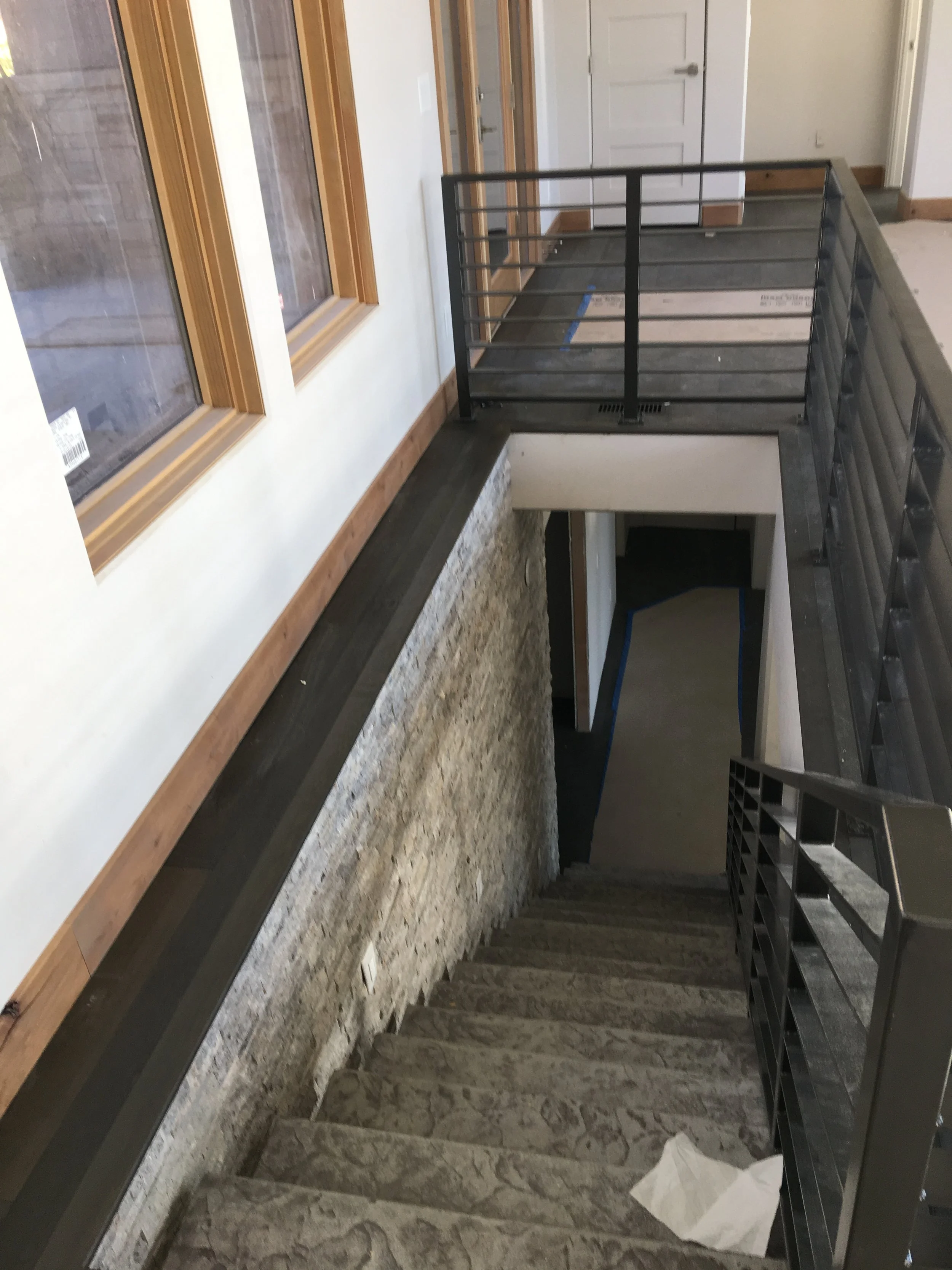 Modern stairwell with steel railings and stone accent wall