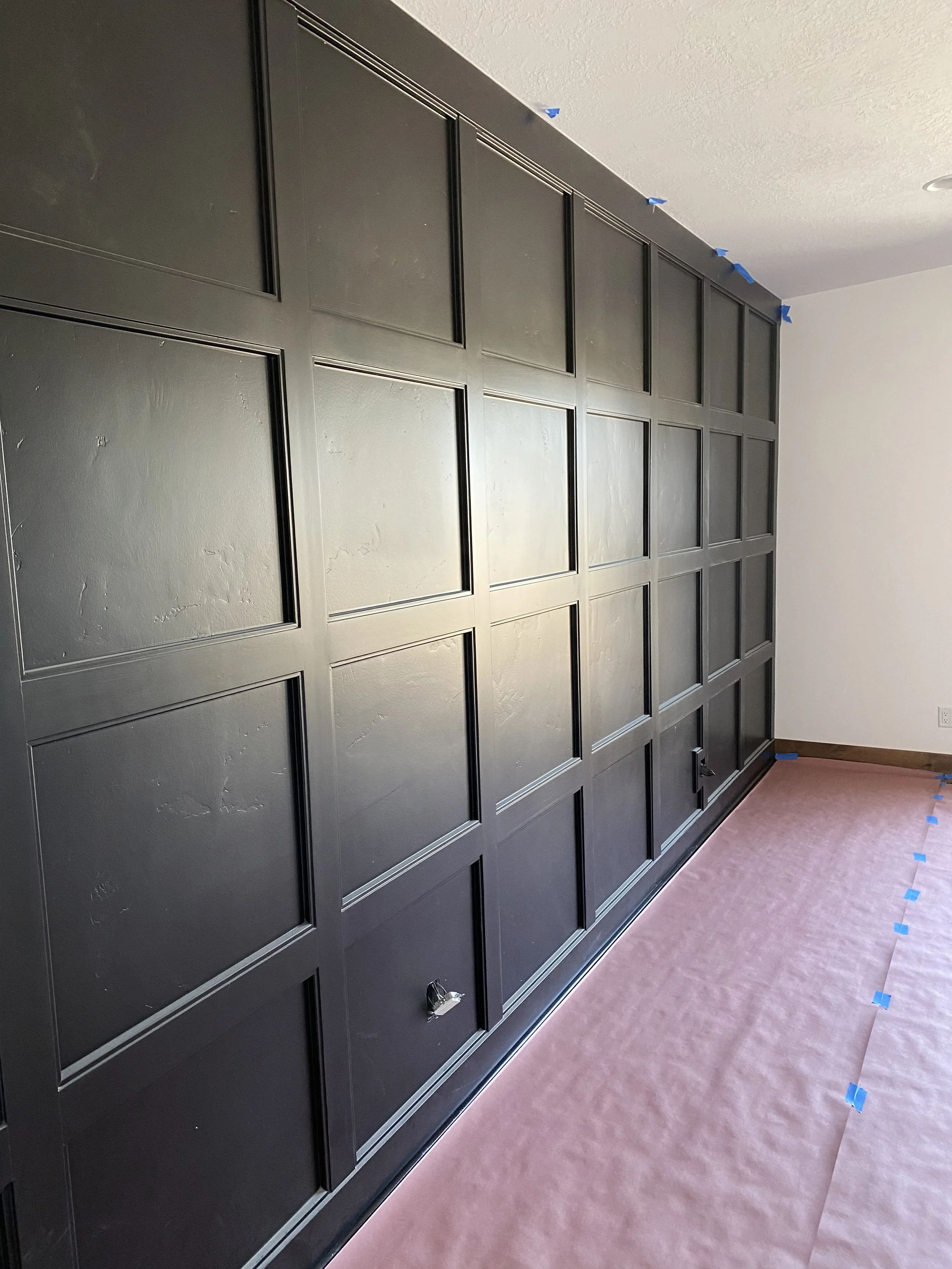 Dark paneled accent wall with shaker-style millwork