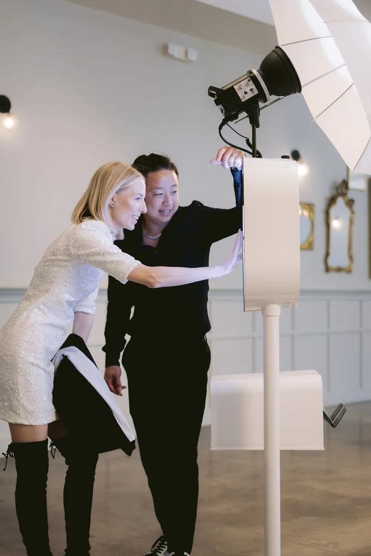 Friendly Wuddabooth attendant guiding a guest on the touchscreen photo booth at an Orange County event