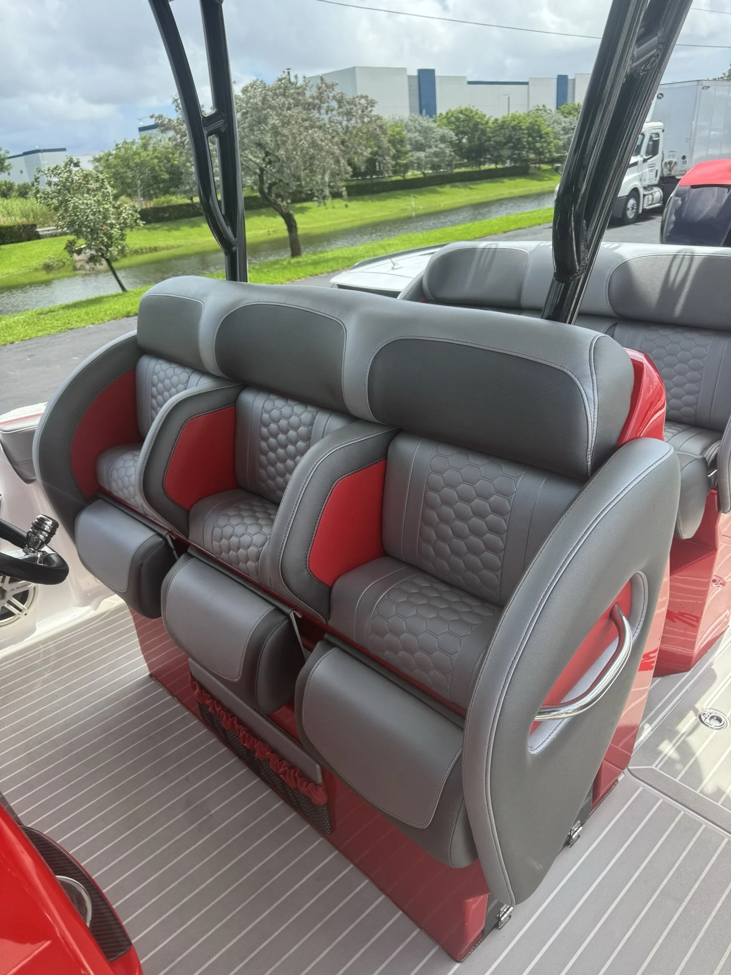 Grey and red hexagon-quilted helm and bolster seating installed on a red high-performance center console