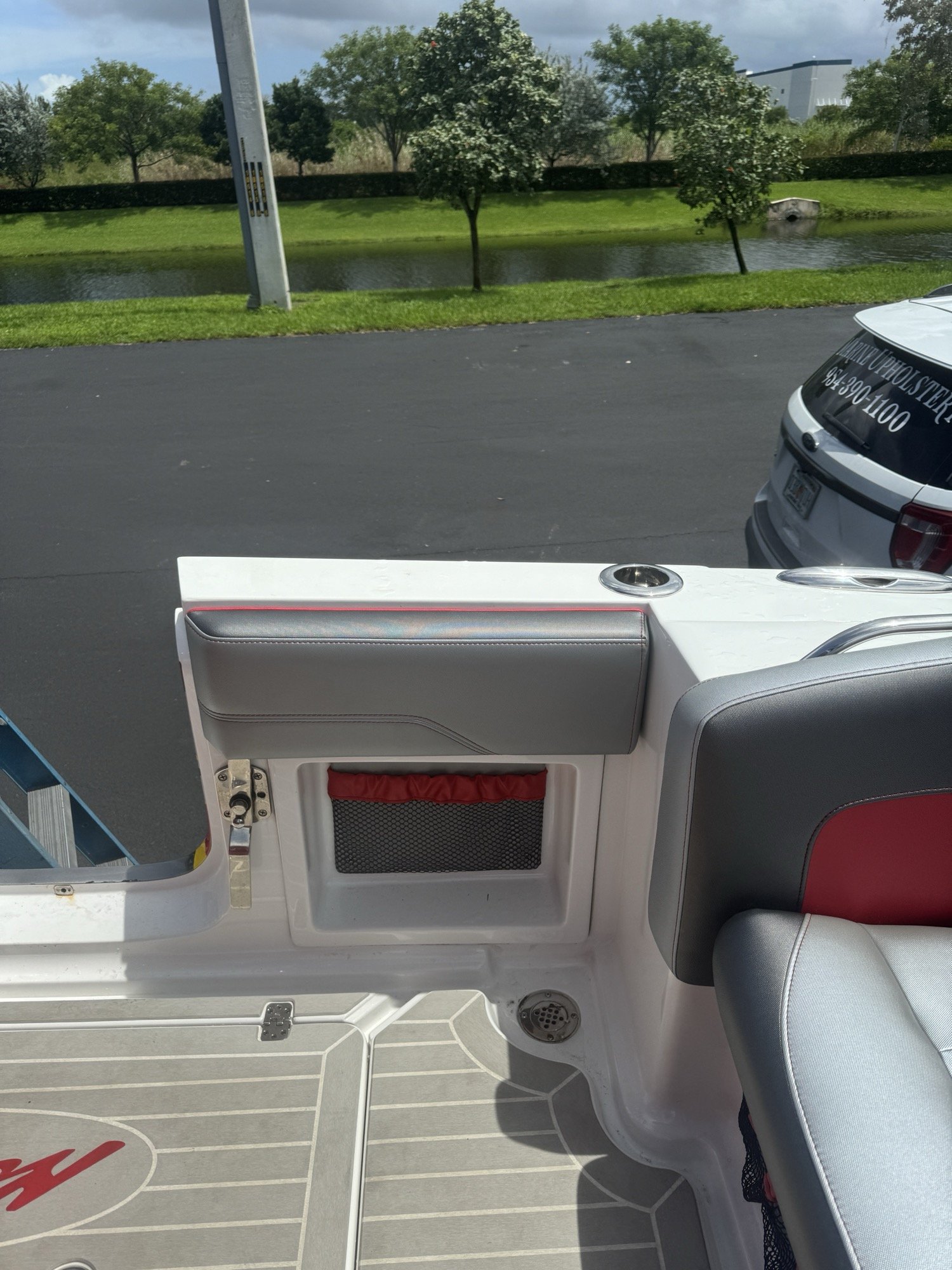 Grey coaming pad with red-trimmed netted storage pocket, built into a white and red center console