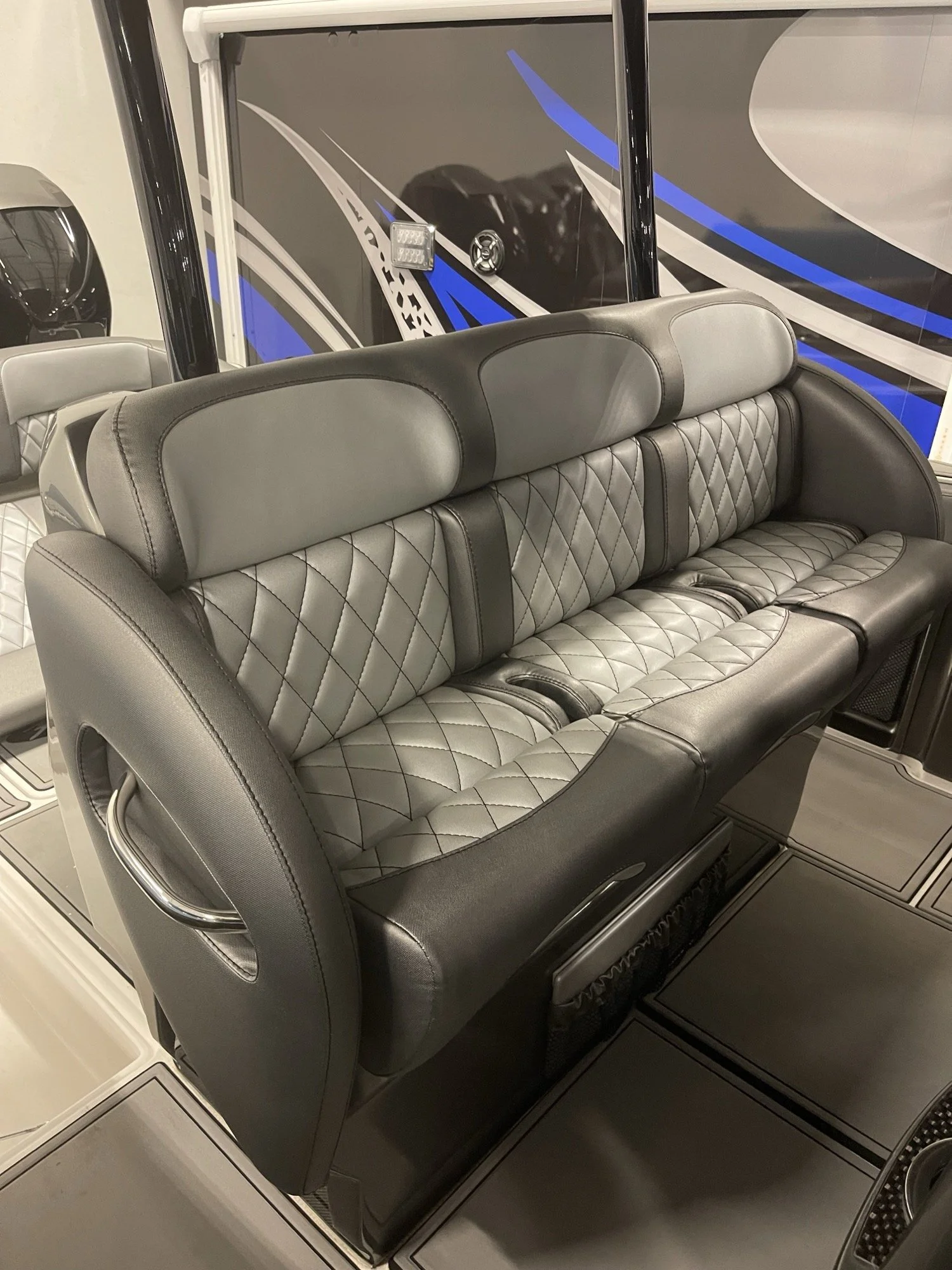 Three-across bench sofa with silver diamond-stitch centre panels, charcoal bolsters and a chrome grab rail, rebuilt by Rivers Refined