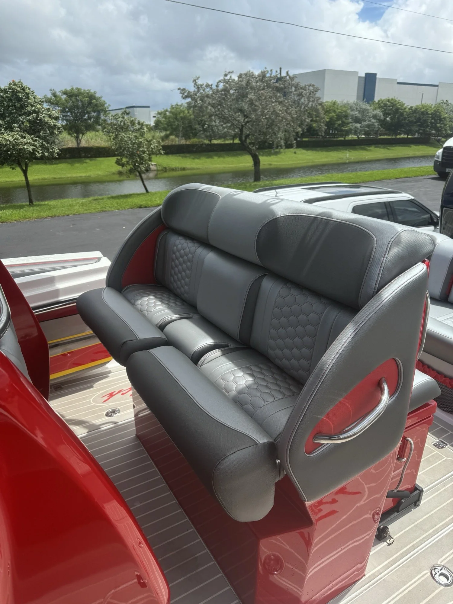 Grey and red hexagon-quilted forward bench with flip bolster, installed on a red high-performance center console