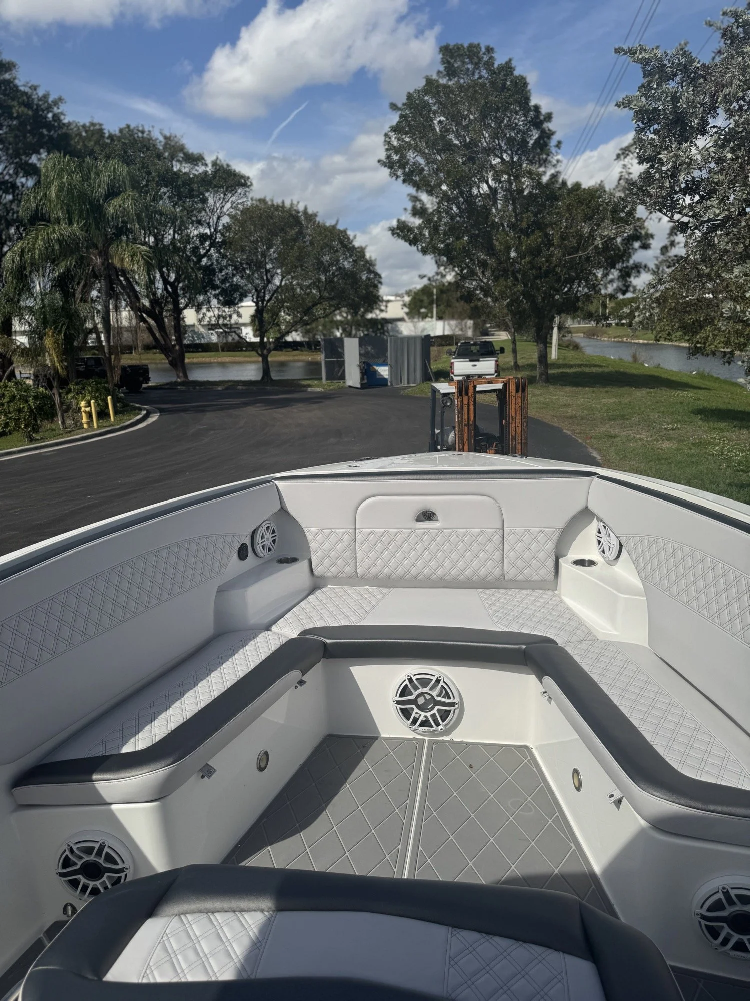 Finished Nor-Tech bow interior in white diamond-stitch vinyl with grey bolsters and matching EVA flooring, built by Rivers Refined in Oakland Park, Florida