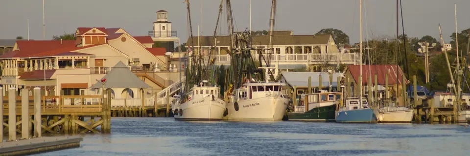 Fishing boats along the Shem Creek waterfront in Mount Pleasant at dusk.