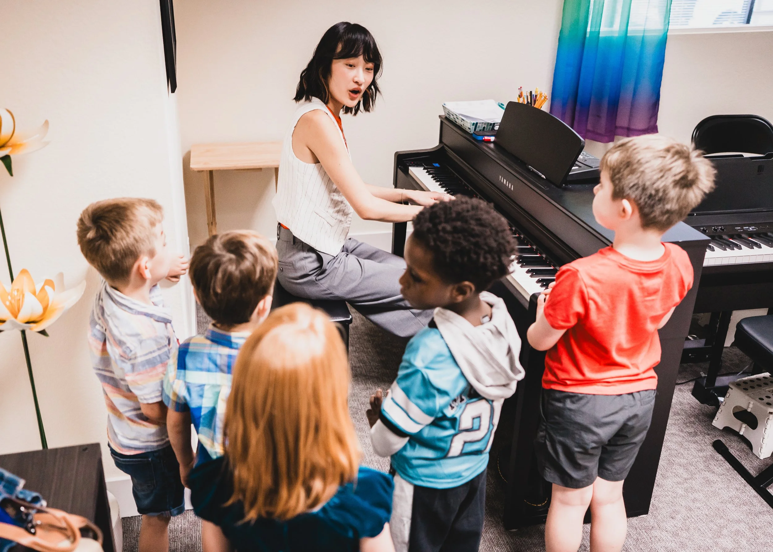Teacher leading children at a piano in a Heart Beats group class