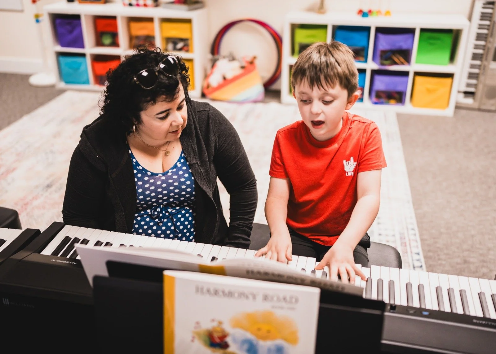 A mother and child making music together at the keyboard