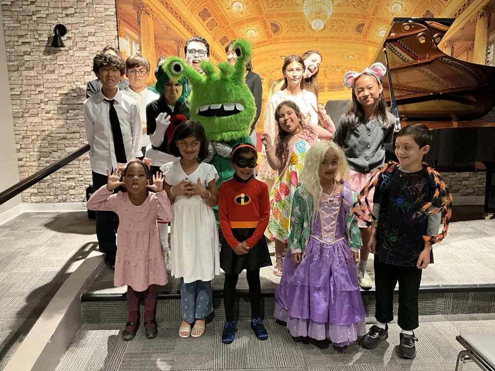 Heart Beats students and teachers celebrating together in costumes after a Halloween recital