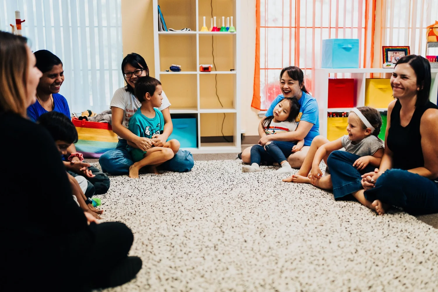 Children and their parents making music together in a classroom circle