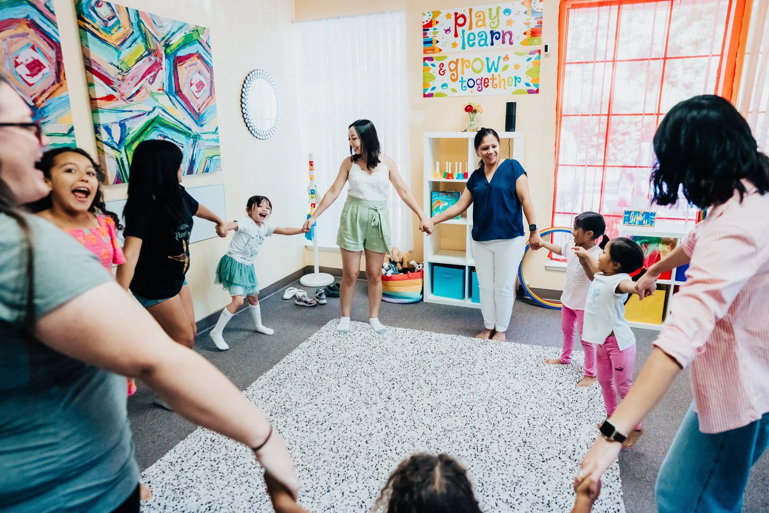 Parents and children holding hands and dancing together in a Harmony Road circle