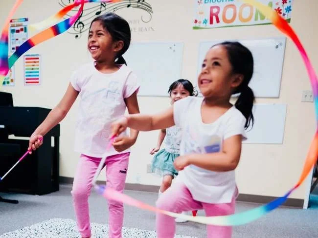 Children moving joyfully during a Heart Beats group class