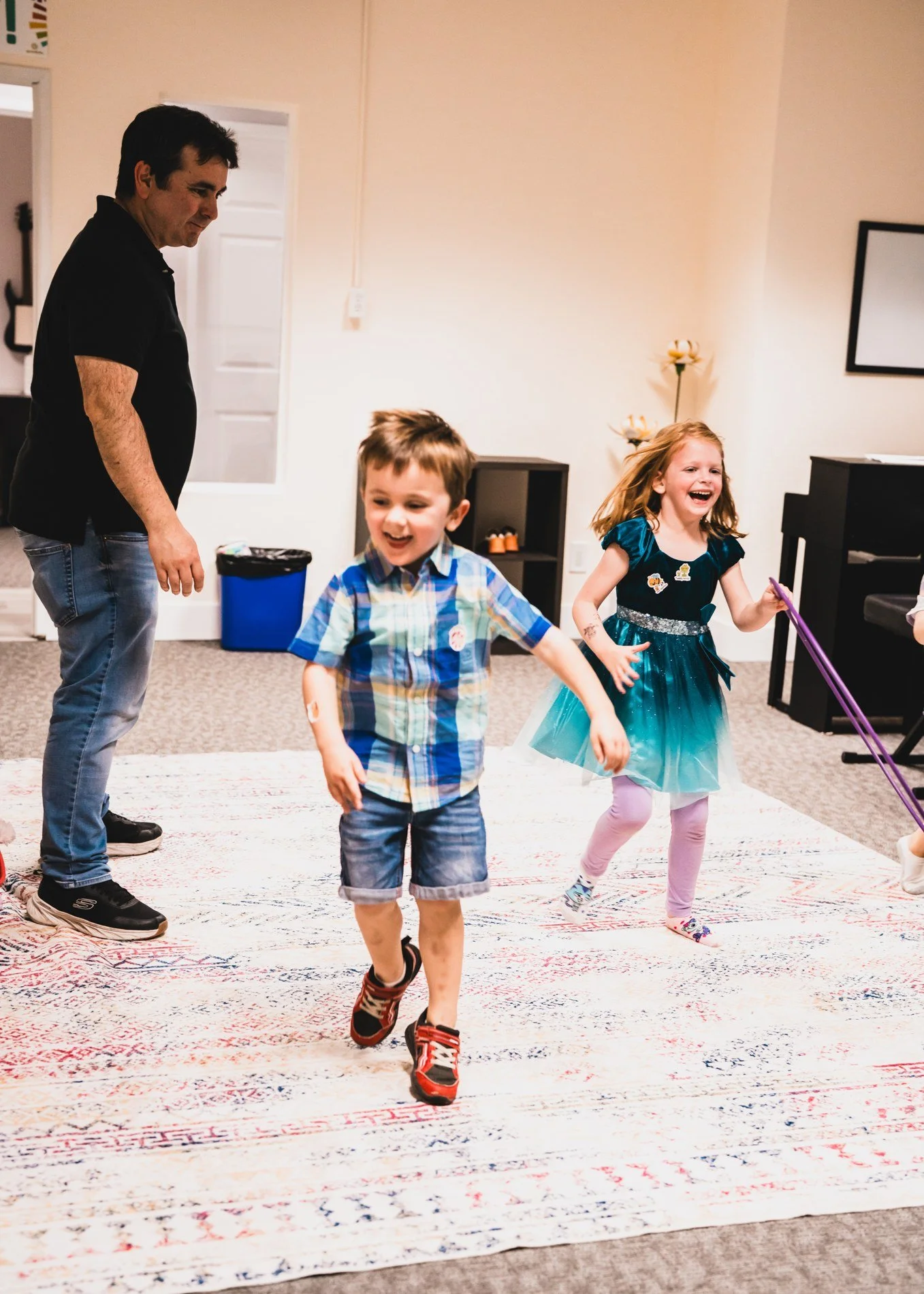 Two children smiling and laughing as they move to music