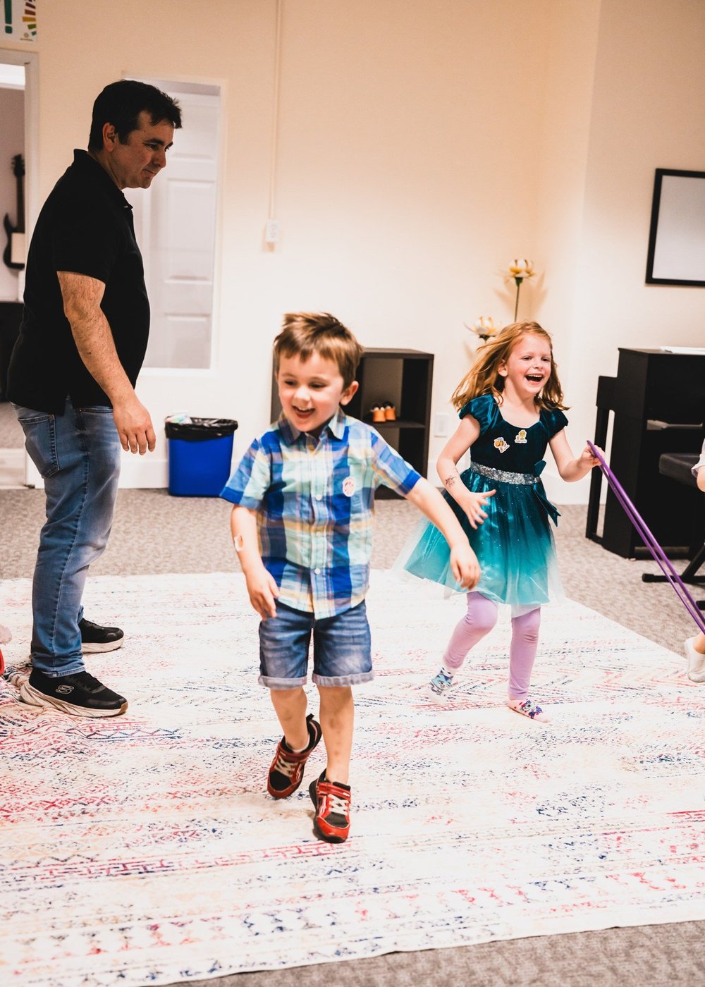 Children and a grown-up participating in a scarf movement activity