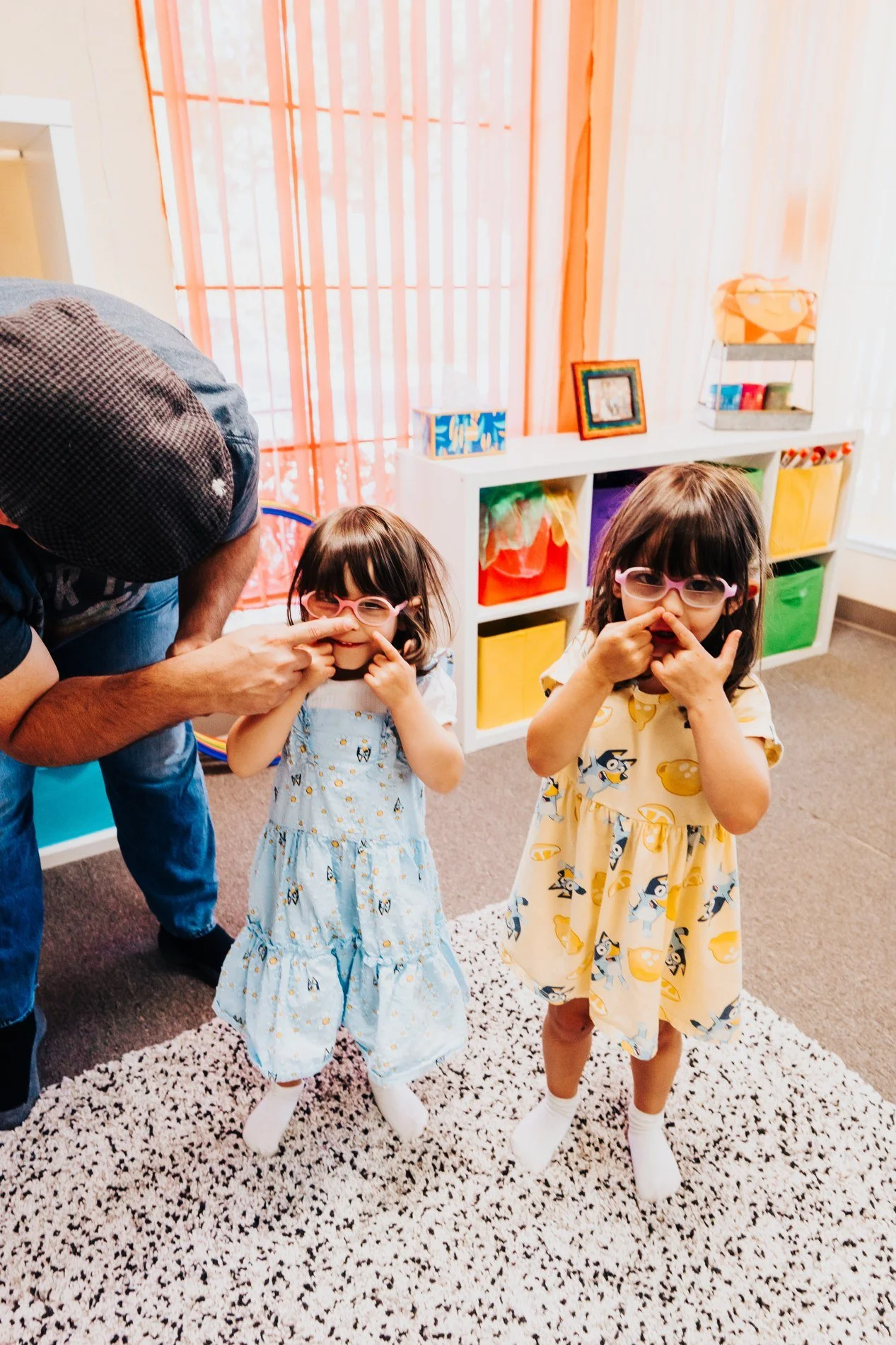 Young children and a grown-up joining in a playful music activity